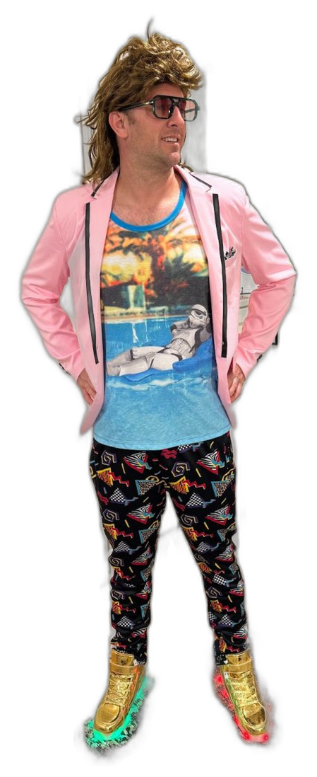John Hawley in a blond mullet wig, pink blazer, 80s pants and gold light-up sneakers
